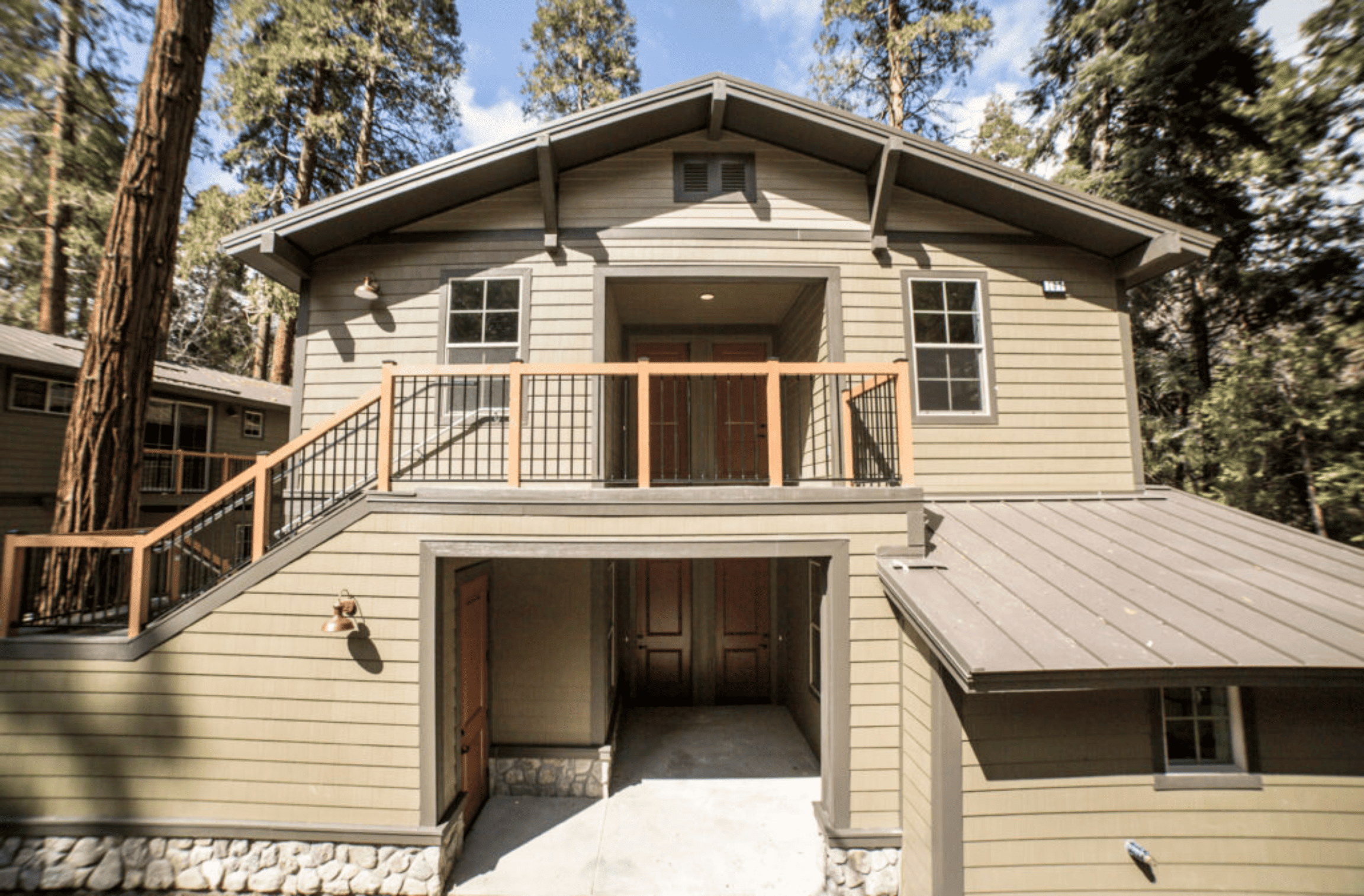 Two story house in the San bernardino mountains that has a green exterior with wood finishings