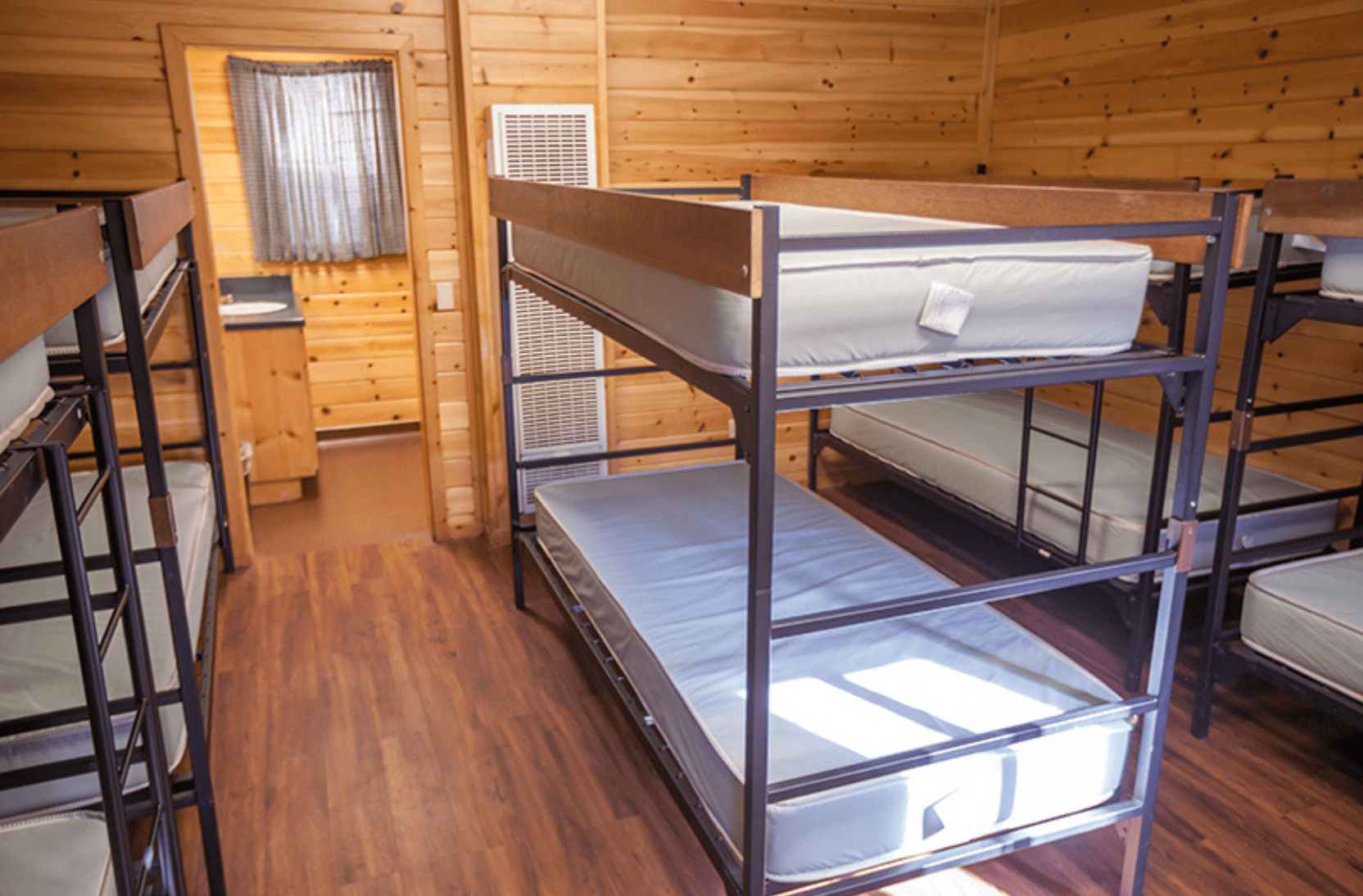 Room full of bunk beds in a wood cabin for campers to sleep